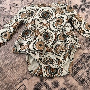 Baby girl patterned onesie with ruffled peplum